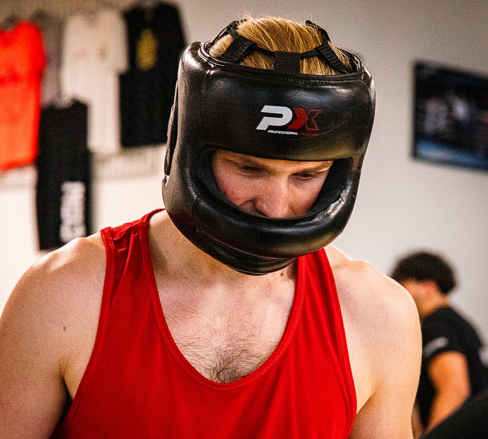 Cours de boxe compétiteurs à Bruxelles : boxeur casqué avant un sparring au club NBS Boxing
