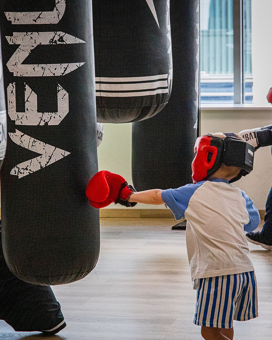 Enfants en cours de boxe éducative au sac de frappe au club NBS Boxing